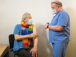 Actor Ian McKellen speaks with Dr. Phil Bennett-Richards as he receives the Pfizer-BioNTech COVID-19 vaccine at the Arts Research Centre, Queen Mary University Hospital, in London, Britain December 16, 2020.