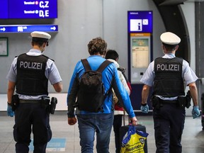 Police escort a group of passengers from the airport's Covid-19 testing center to their gate at Frankfurt International Airport in Frankfurt am Main, western Germany, on Dec. 21, 2020.