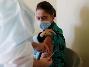 FILE: A medical worker receives the Pfizer-BioNTech coronavirus disease (COVID-19) vaccine.