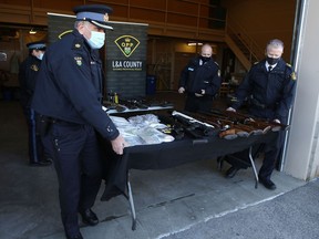 The OPP and the Tyendinaga Police Service display the weapons and drugs seized in raids on a pair of residences near Deseronto, in Napanee on Friday.