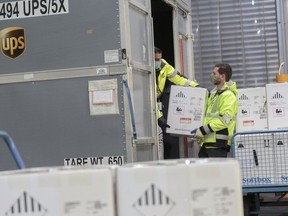 UPS workers load test shipments of COVID-19 vaccine in Cologne, Germany of Friday.