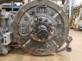 A view of a mounted wheel showing 12 lug nuts, three jacking screws (circles) and four grounding cables. One jacking screw is obscured by a grounding cable.