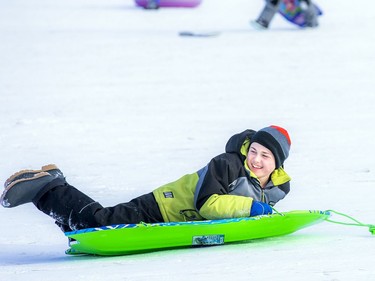 People were well spaced apart and respecting the guidelines Saturday Jan. 9, 2021, while enjoying the beautiful sunshine and tobogganing at  Carlington Park hill. 12-year-old Maxwell McKay was all smiles flying down the massive hill in Carlington Park.