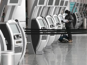 Files: A lone passenger uses the automatic check-in counter at Montreal-Trudeau airport.