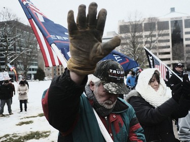 LANSING, MI - JANUARY 06: Supporters of President Donald Trump join in a mass prayer out front of the Michigan State Capitol Building to protest the certification of Joe Biden as the next president on January 6, 2021 in Lansing, Michigan. Trump supporters gathered at state capitals across the country to protest today's ratification of President-elect Joe Biden's Electoral College victory over President Trump in the 2020 election.