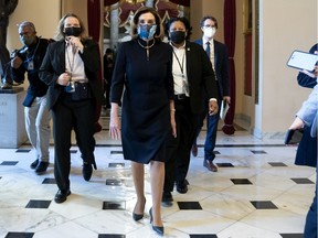 Speaker of the House Nancy Pelosi (D-CA) (C) wears a protective mask while walking to the House Floor at the U.S. Capitol on January 13, 2021 in Washington, DC.