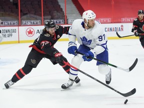 Thomas Chabot of the Ottawa Senators and Joe Thornton of the Toronto Maple Leafs chase down a loose puck at Canadian Tire Centre on Friday.