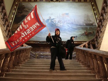 WASHINGTON, DC - JANUARY 06: A protester holds a Trump flag inside the US Capitol Building near the Senate Chamber on January 06, 2021 in Washington, DC. Congress held a joint session today to ratify President-elect Joe Biden's 306-232 Electoral College win over President Donald Trump. A group of Republican senators said they would reject the Electoral College votes of several states unless Congress appointed a commission to audit the election results.
