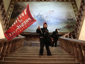 WASHINGTON, DC - JANUARY 06: A protester holds a Trump flag inside the US Capitol Building near the Senate Chamber on January 06, 2021 in Washington, DC.