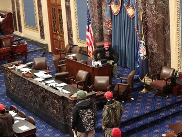 WASHINGTON, DC - JANUARY 06: Protesters enter the Senate Chamber on January 06, 2021 in Washington, DC. Congress held a joint session today to ratify President-elect Joe Biden's 306-232 Electoral College win over President Donald Trump. Pro-Trump protesters have entered the U.S. Capitol building after mass demonstrations in the nation's capital.