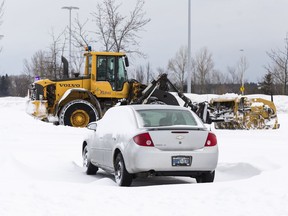 A file photo of a CIty of Ottawa city plough clears the parking lot of snow at the Fallowfield Transit Station following a winter storm in Ottawa on February 13, 2019.