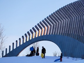 People enjoy sliding adjacent to the light sculpture "Moving Surfaces" at Lansdowne Park on Monday, Jan. 18, 2021.