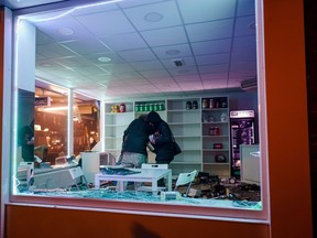 A pair of protesters loot a Rotterdam shop during overnight protests.