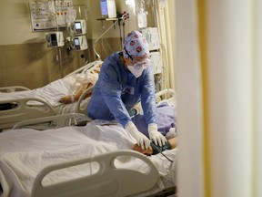 FILE: A nurse attends to a patient suffering from the coronavirus disease (COVID-19).