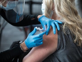 A woman receives the COVID-19 vaccine at Gillette Stadium on January 15, 2021 in Foxborough, Massachusetts. First responders and healthcare workers will be first to recieve the vaccinations at the stadium, starting with around 300 people per day, but advancing to thousands per day soon after.