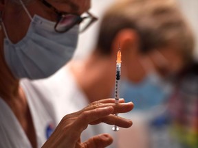 FILE: A nurse fills a syringe with the Pfizer-BioNtech coronavirus disease (Covid-19) vaccine.