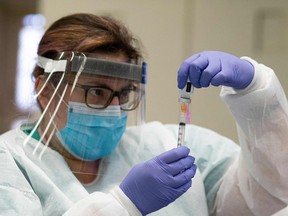 A nurse prepares a dose of the Moderna coronavirus disease (COVID-19) vaccine at a vaccination site at South Bronx Educational Campus, in the Bronx New York on January 10, 2020. (Photo by Kena Betancur / AFP)