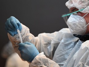 Files: A medical worker holds a swab sample taken for Covid-19 testing