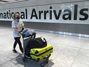 (FILES)  A passenger wearing a face covering due to the COVID-19 pandemic, arrives at an airport.