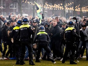 An anti-government activist face off with Dutch police during a protest to denounce ongoing restrictions related to the coronavirus disease (COVID-19) pandemic in Museumplein, Amsterdam on Sunday.