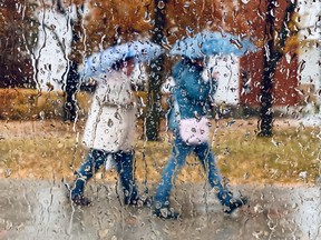 Two people walk with umbrellas in a file photo