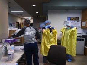 Files: ICU health-care workers don PPE before entering a negative pressure room to care for a COVID-19 patient on a ventilator at a Toronto hospital.