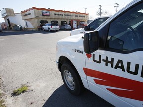 Vehicles are parked in front of a U-Haul store waiting for DIY movers.