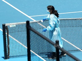 FILE PHOTO: A staff member wearing PPE works to clean surfaces at Melbourne Park in between training sessions for tennis players undergoing mandatory quarantine in advance of the Australian Open in Melbourne, Australia, January 21, 2021.