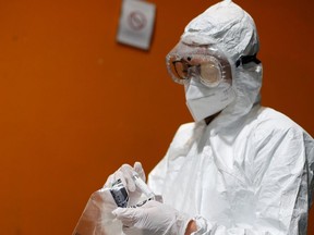A medical worker, wearing a protective suit and a face mask.