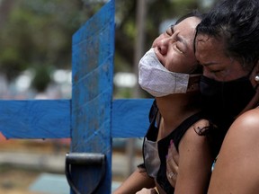 FILE PHOTO: Kelvia Andrea Goncalves, 16, is supported by her aunt Vanderleia dos Reis Brasao, 37, as she reacts during the burial of her mother Andrea dos Reis Brasao, 39, who passed away due to the coronavirus disease (COVID-19) at Delphina Aziz hospital, at the Parque Taruma cemetery in Manaus, Brazil, January 17, 2021.