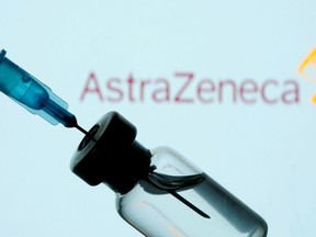 FILE PHOTO: A vial and syringe are seen in front of a displayed AstraZeneca logo