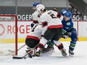 Vancouver Canucks forward Antoine Roussel (26) battles with Ottawa Senators defenseman Mike Reilly (5) in front of  goalie Marcus Hogberg (1) on a goal scored by Vancouver Canucks forward Tyler Motte (64) in the third period at Rogers Arena. Vancouver won 5-1.