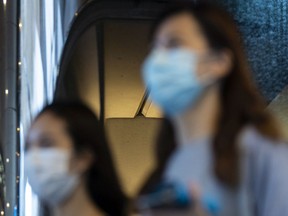 FILE: Two pedestrians wearing protective masks.