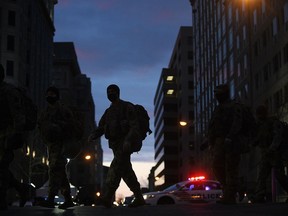 National Guard troops march through the downtown area of Washington on Sunday, Jan. 17, 2021. MUST CREDIT: Photo for The Washington Post by Astrid Riecken