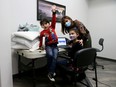 Mary Bishai is a physiotherapist who brings her children  Nicholas, left, and Chantal to work in Ottawa while schools are closed.