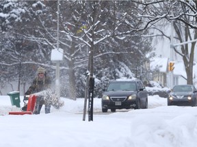 Keith Woolhouse cleans a laneway along Island Park Drive in Ottawa on Thursday.