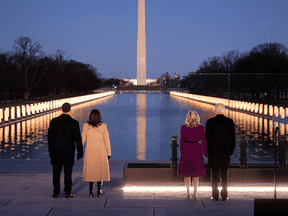 Douglas Emhoff, U.S. Vice President-elect Kamala Harris, Jill Biden and President-elect Joe Biden look down the National Mall as lamps are lit to honour the nearly 400,000 American victims of the coronavirus pandemic at the Lincoln Memorial Reflecting Pool January 19, 2021 in Washington