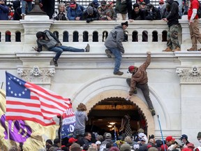 A mob of protesters scales the walls at the U.S. Capitol Building in Washington on Jan. 6.