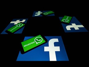 This file photo taken on October 5, 2020 shows the logo of US social network Facebook and mobile messaging service WhatsApp on the screens of a smartphone and a tablet in Toulouse, southwestern France. Secure messaging app Signal is at the top downloads on Apple Store and Google Play platforms in several countries after the popular messaging app WhatsApp asked its some two billion users on January 7, 2021 to accept new terms that will allow it to share more information with its parent company Facebook.