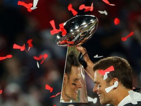 TAMPA, FLORIDA - FEBRUARY 07: Tom Brady #12 of the Tampa Bay Buccaneers celebrates as he is reflected in the Lombardi Trophy after defeating the Kansas City Chiefs in Super Bowl LV at Raymond James Stadium on February 07, 2021 in Tampa, Florida. The Buccaneers defeated the Chiefs, 31-9.