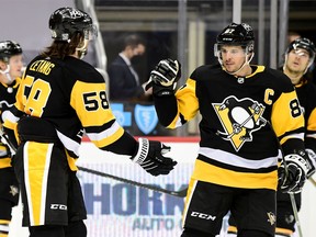 Sidney Crosby (right) of the Pittsburgh Penguins congratulates Kris Letang on a goal against the New York Islanders, February 20, 2021.