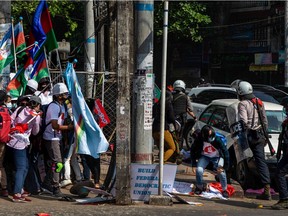 YANGON, MYANMAR - FEBRUARY 27: Riot police charge at anti-coup protesters on February 27, 2021 in Yangon, Myanmar. Myanmar's military government has intensified a crackdown on protesters in recent days, using tear gas, charging at and arresting protesters and journalists.