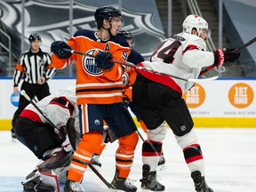 Edmonton Oilers' Ryan Nugent-Hopkins (93) battles Ottawa Senators' Erik Gudbranson (44) in front of goaltender Marcus Hogberg (1) during third period NHL action at Rogers Place in Edmonton, on Tuesday, Feb. 2, 2021.