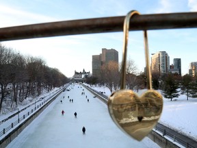 OTTAWA - Feb 3, 2021 - Skaters take to the Rideau Canal Skateway behind one of the "locks of love" placed on the Corktown Bridge on a mild February day in Ottawa on Wednesday.