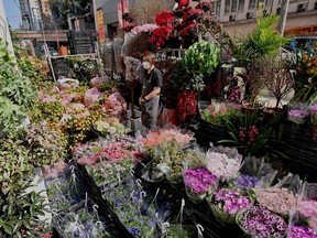A vendor stands next to flowers for sale in Hong Kong on Feb. 3.