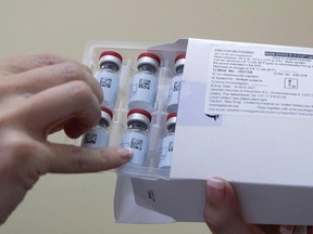 A healthcare worker holds vials containing doses of the Johnson & Johnson vaccine against the COVID-19 coronavirus.