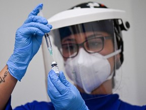FILE: A health worker prepares a dose of the Pfizer-BioNTech vaccine against COVID-19.