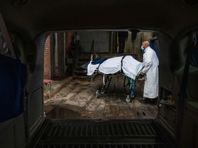 FILE: In this file photo taken on December 24, 2020 Maryland Cremation Services transporter Reggie Elliott brings the remains of a Covid-19 victim to his van from the hospital's morgue in Baltimore, Maryland during the Covid-19 pandemic. - The US death toll from Covid-19 is approaching a grim milestone: Half a million people in this country dead from the coronavirus.