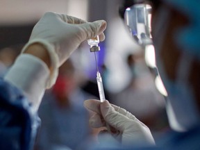 FILE: A health worker prepares a dose of COVID-19 vaccine.