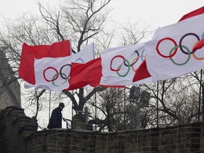 A security person stands near the Olympic flags during a ceremony to mark the arrival of the Olympic flag and start of the flag tour for the Winter Olympic Games Beijing 2022 at a section of the Great Wall of China in Beijing back in 2018.